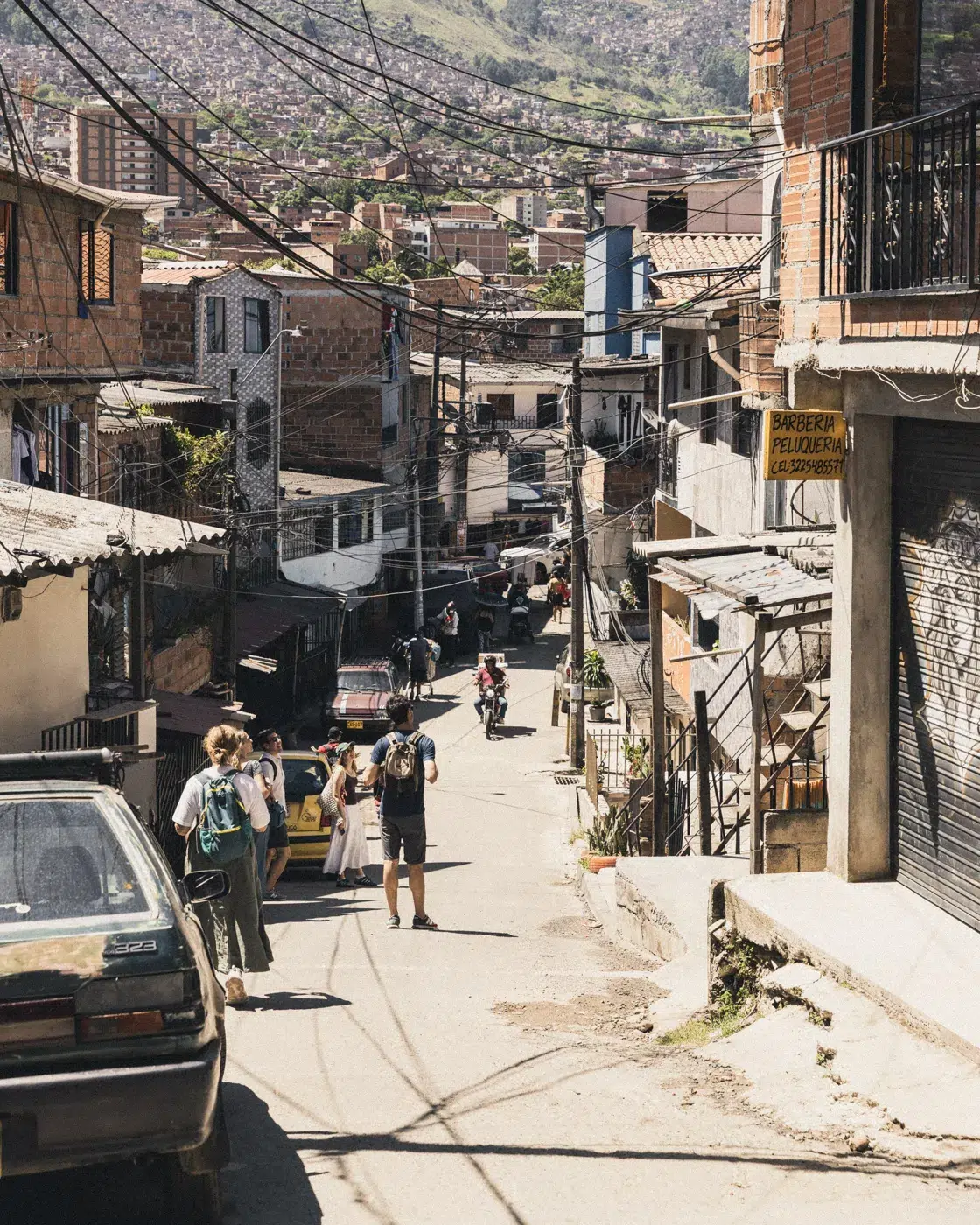 Straßenszene in der Comuna 4 Medellín – Einheimische und Besucher in einem Wohnviertel mit Blick auf die Stadt