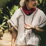 Guide auf einer Kaffeetour bei Medellín zeigt eine rote Kaffeekirsche