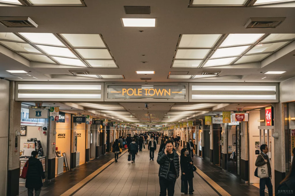 Belebte Einkaufspassage in der unterirdischen „Pole Town“ in Sapporo, Japan – mit zahlreichen Geschäften, Restaurants und Passanten in Winterkleidung.