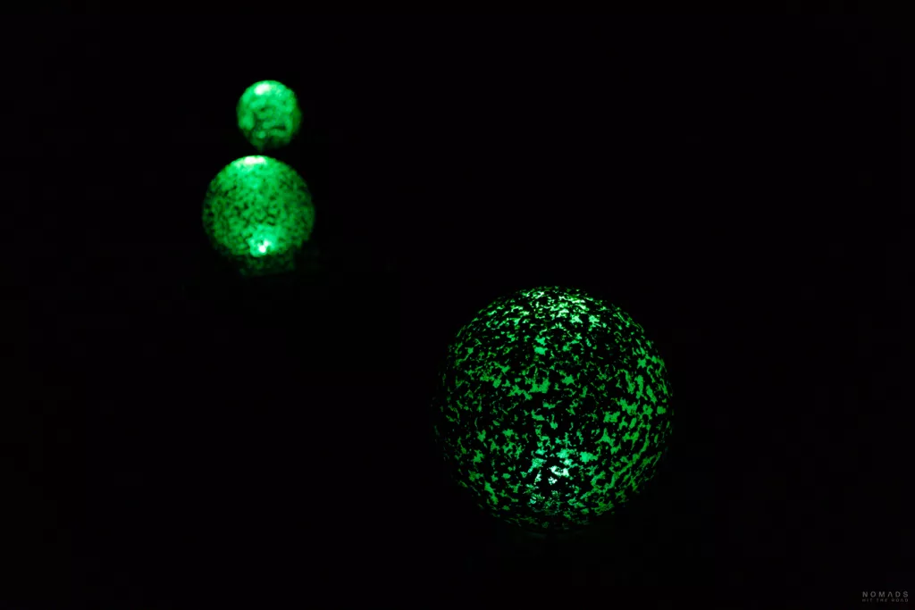 Leuchtende grüne Kugeln im Dunkeln – poetische Lichtinstallation auf dem Kamuy Lumina Pfad.