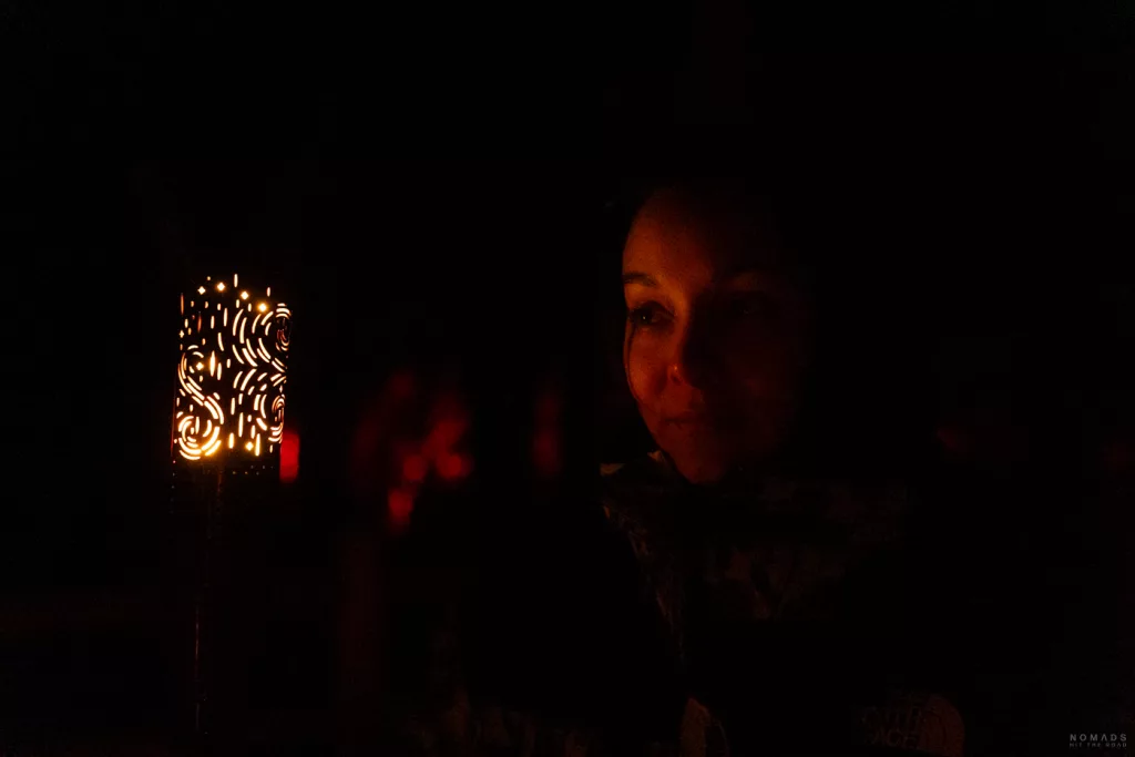 Ein Gesicht im Schein einer kunstvoll durchbrochenen Laterne – persönliche und intime Stimmung auf dem nächtlichen Spaziergang.
