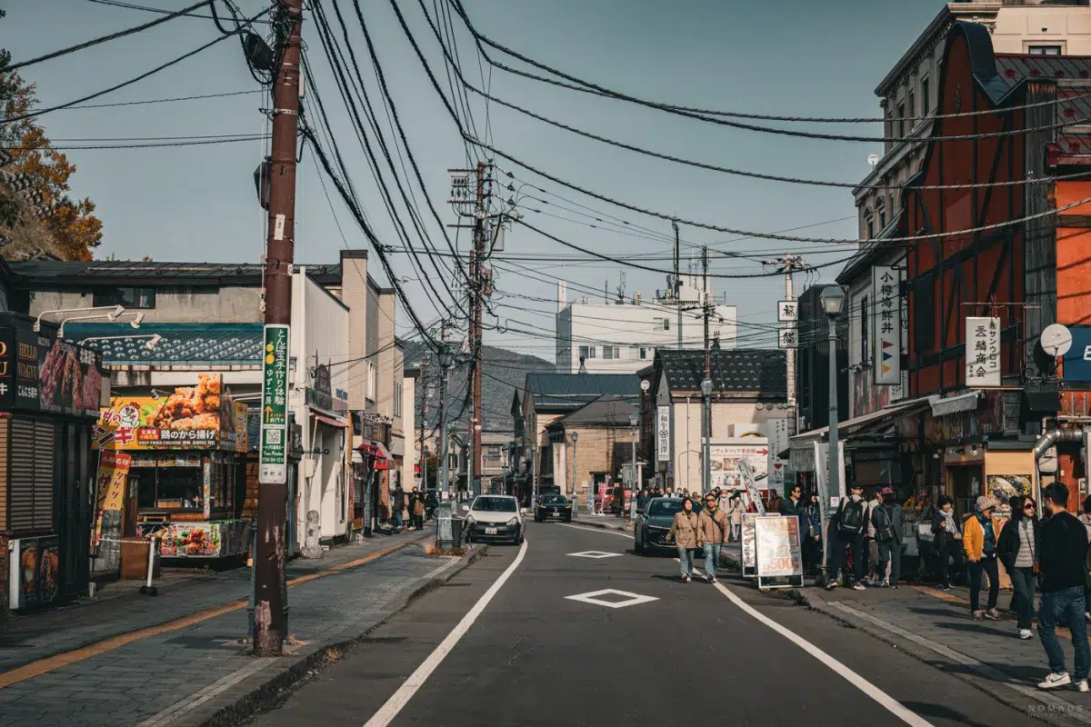 Belebter Abschnitt der Sakaimachi Street in Otaru, mit Restaurants, bunten Schildern und vielen Besuchern entlang der historischen Einkaufsstraße.