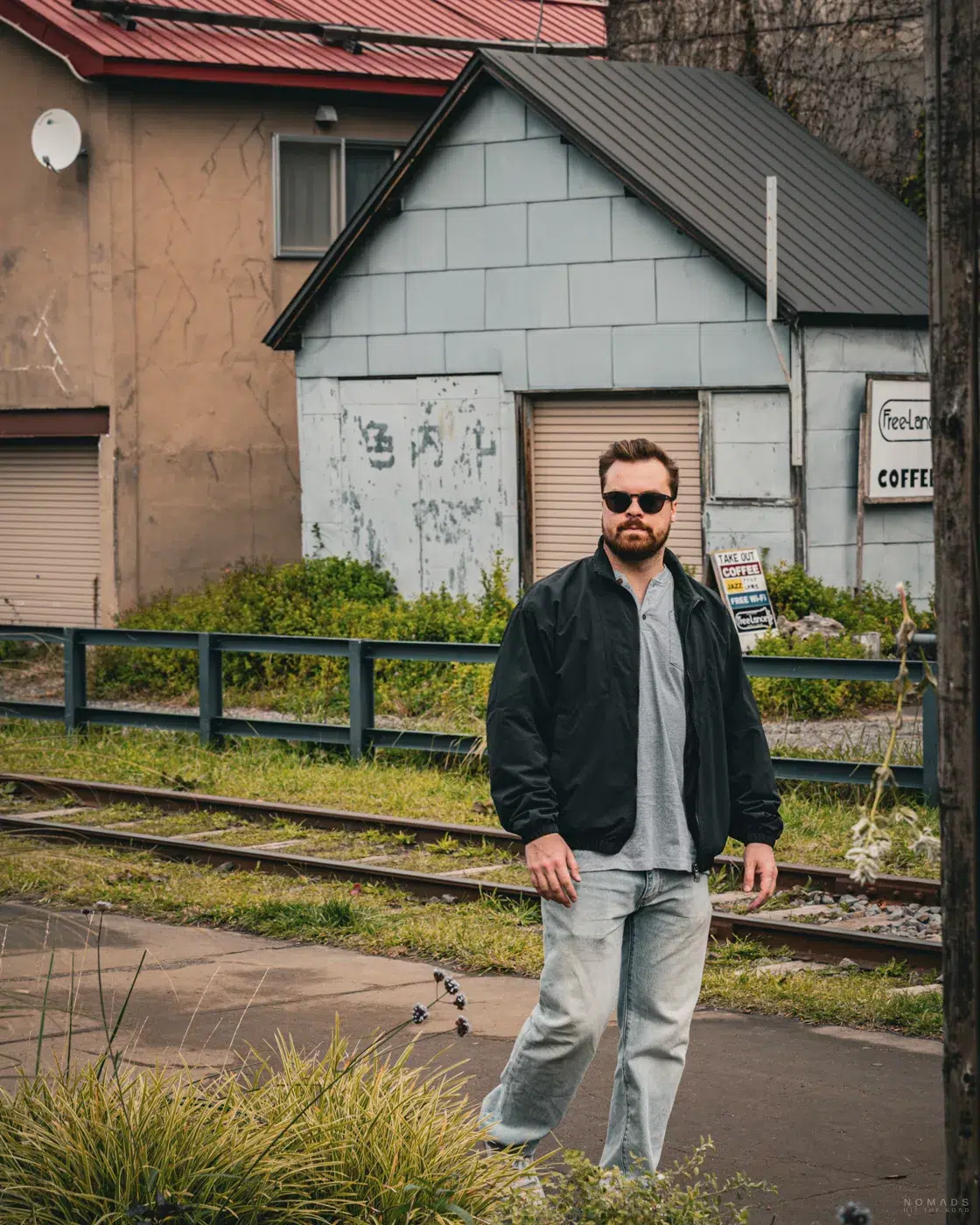 Spaziergänger an der stillgelegten Temiya-Bahnlinie in Otaru, umgeben von alten Häusern und herbstlicher Stimmung.