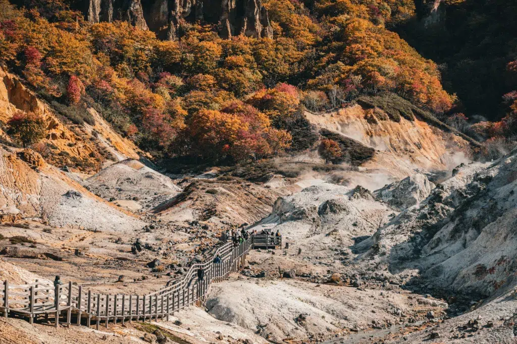 olzstege durch das Jigokudani Valley in Noboribetsu im Herbst, umgeben von dampfenden Schwefelquellen