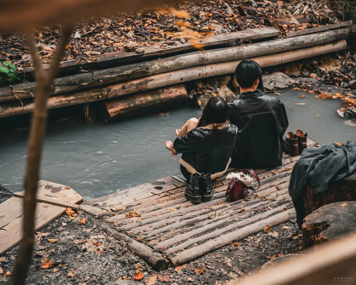 Besucher entspannen ihre Füße im Oyunuma River Foot Bath in Noboribetsu, einer natürlichen heißen Quelle mitten im Wald.