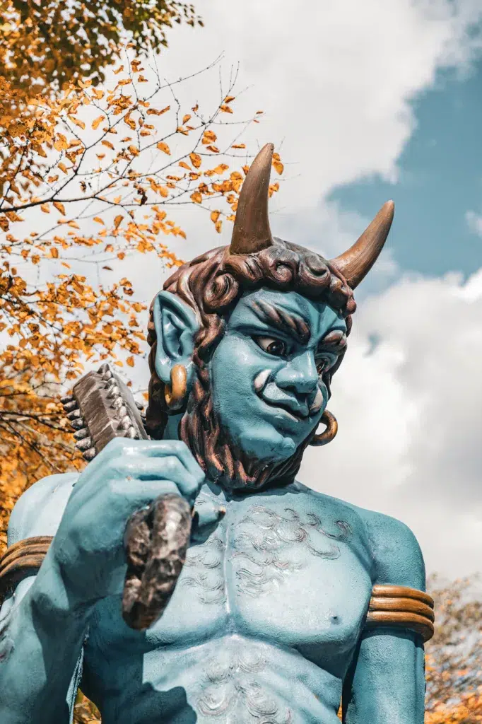 Dämonenstatue (Oni) in Noboribetsu, Hokkaido, mit herbstlichen Bäumen im Hintergrund – typisches Motiv des Onsen-Ortes