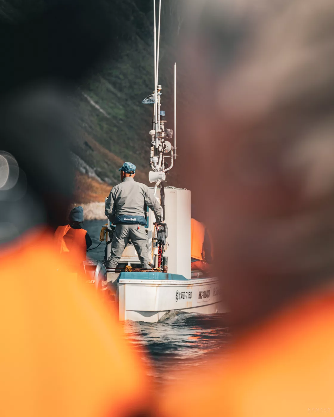 Blick auf den Bootsführer und die Ausrüstung eines kleinen Ausflugsboots während einer Wildlife-Boat-Tour entlang der Küste von Shiretoko.