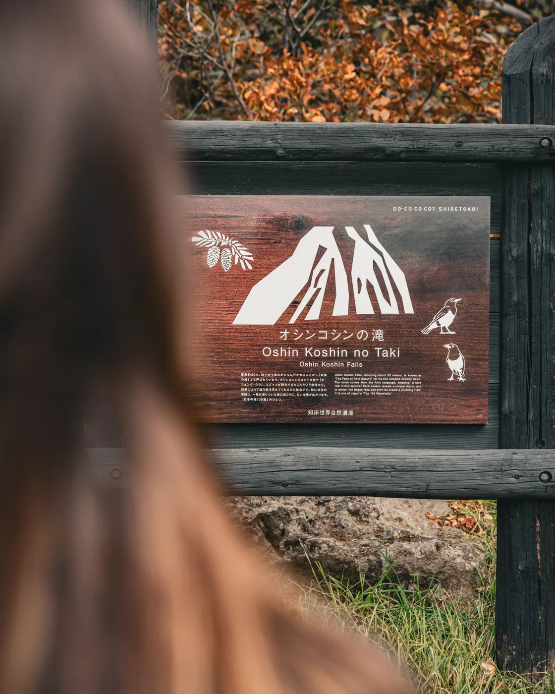 Hinweisschild zu den Oshin Koshin Falls im Shiretoko-Nationalpark, eingebettet in die umliegende Natur