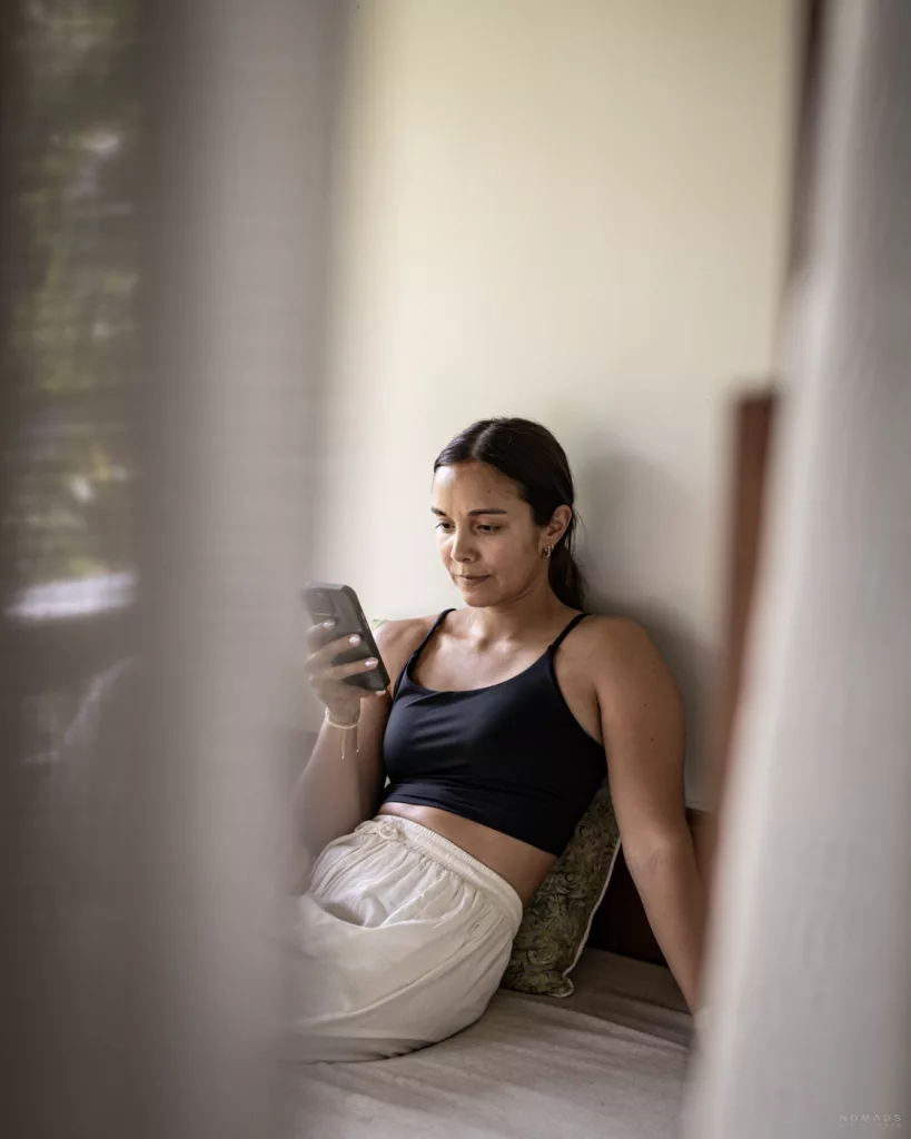 eSIM Bali Erfahrung: Frau checkt Internetverbindung am Handy in der Unterkunft