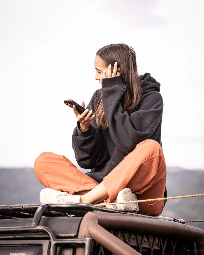 Reisende auf Bali nutzt ihr Smartphone unterwegs – mobiles Internet während eines Ausflugs