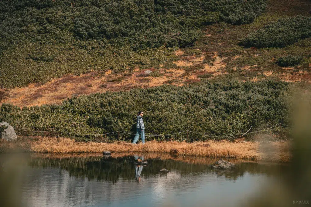 Wanderer auf dem Rundweg am Sugatami-See unterhalb des Asahidake im Daisetsuzan National Park auf Hokkaido