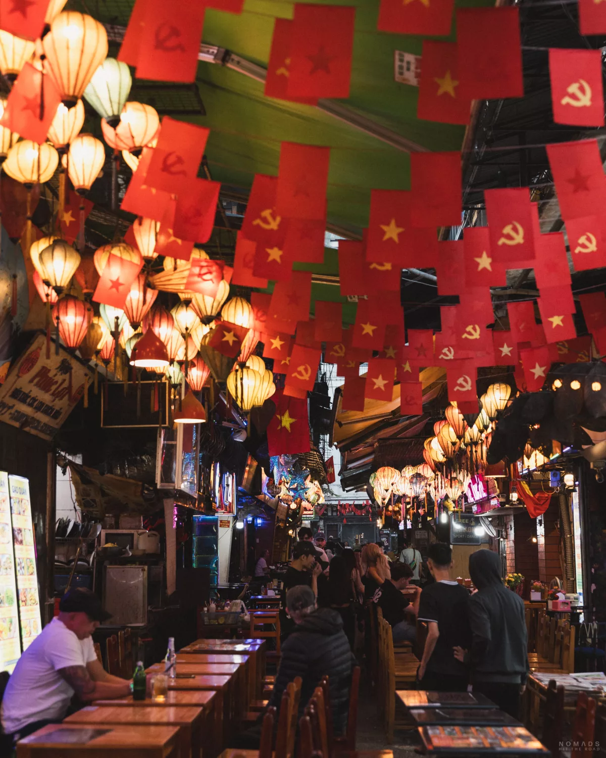 Ta Hien Beer Street mit Sitzplätzen und Flaggen sowie Lampen an der Decke