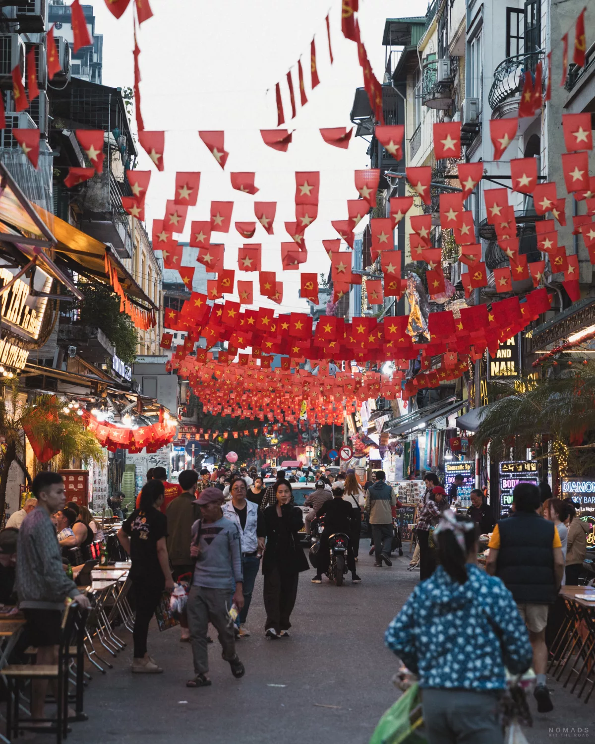 Ta Hien Beer Street durch die Menschen laufen, behangen mit Vietnam Flaggen