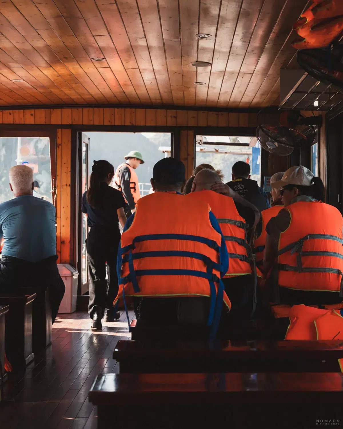 Menschen mit Rettungswesten im Beiboot auf dem Weg zum Schiff in der Halong Bay