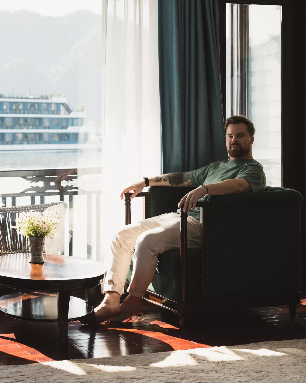 Mann sitzt in einem Sessel an Bord der La Regina in der Halong Bay