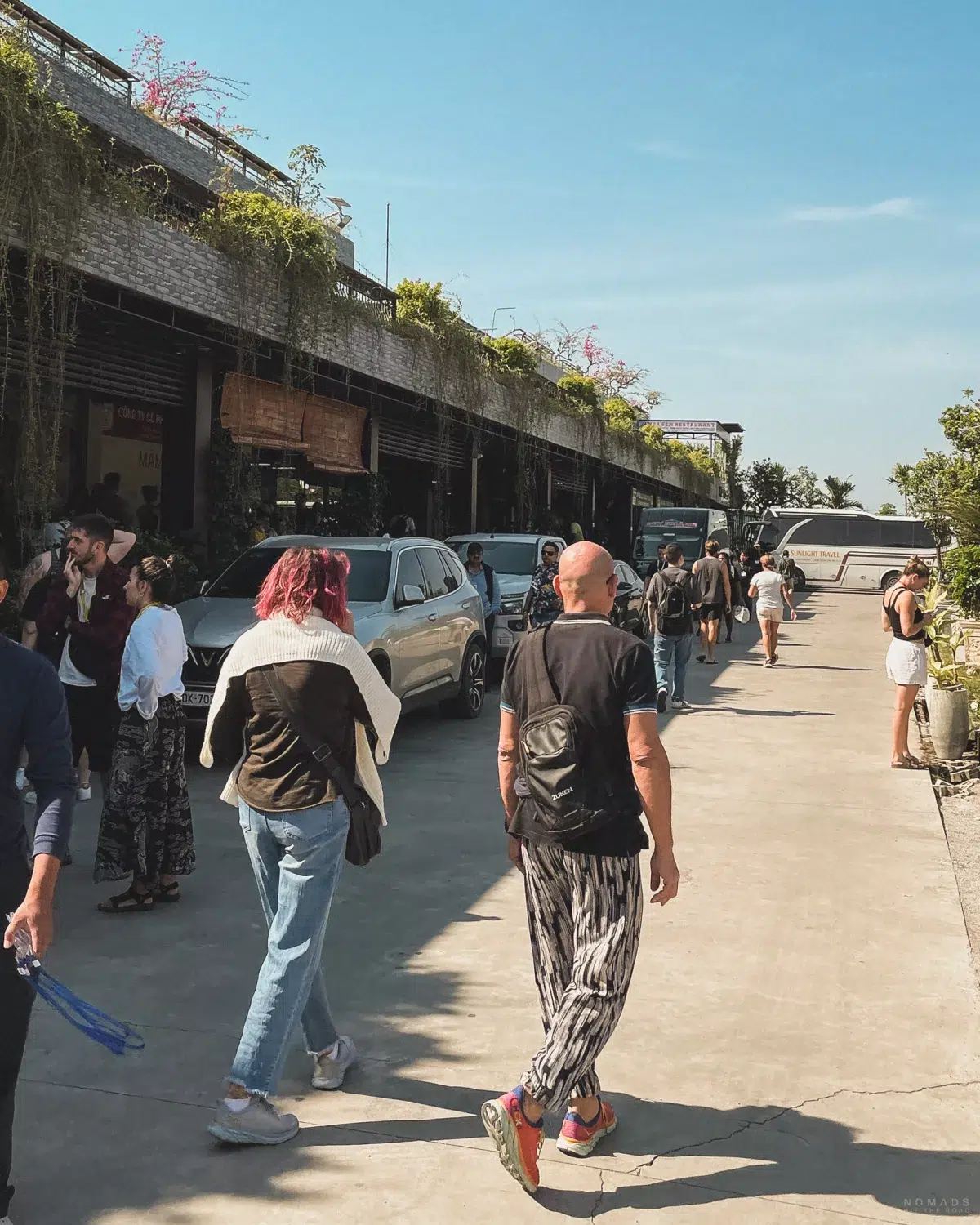 Menschen laufen auf dem Parkplatz vor einem Gebäude