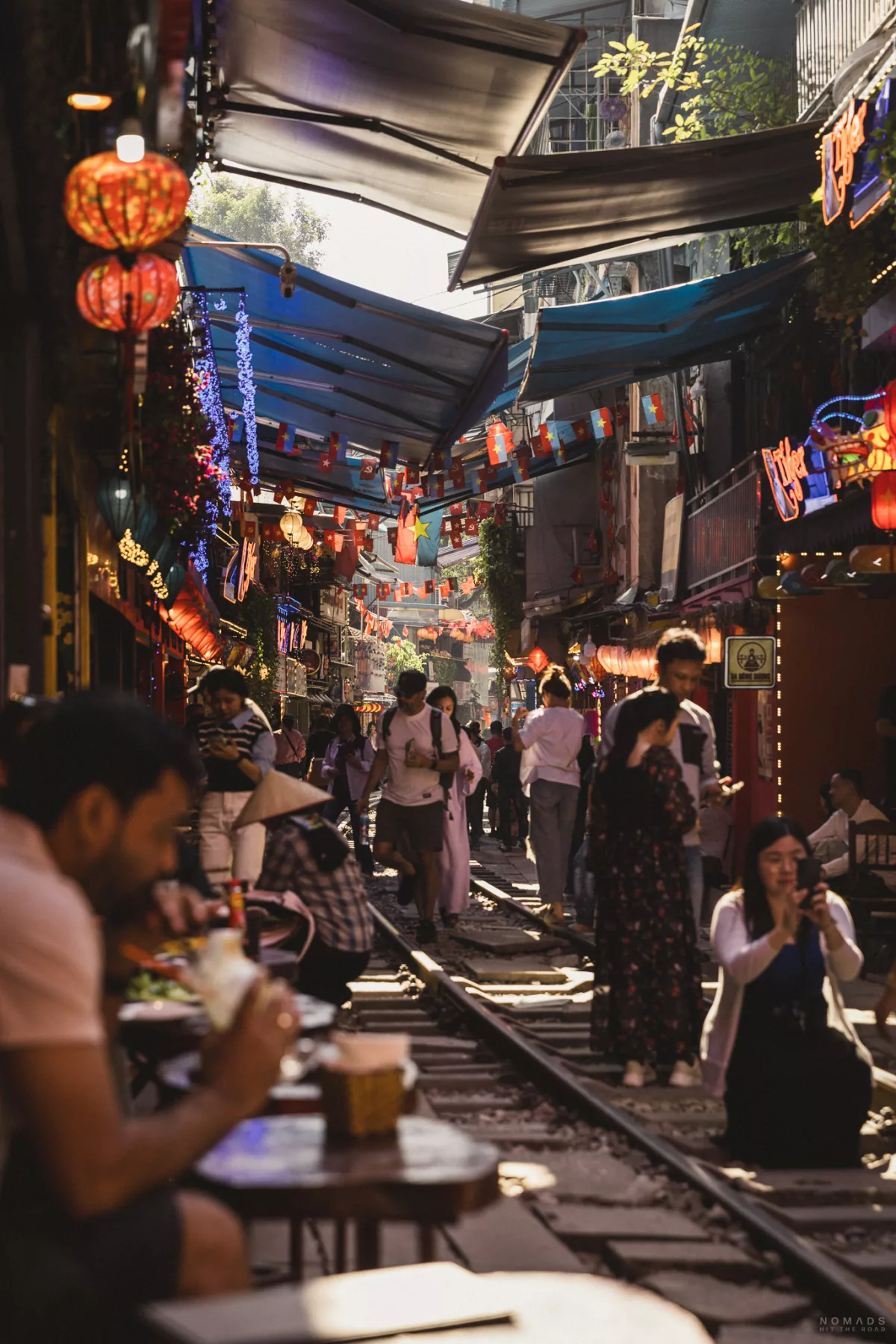 Menschen sitzen in Cafés und machen Fotos auf den Gleisen
