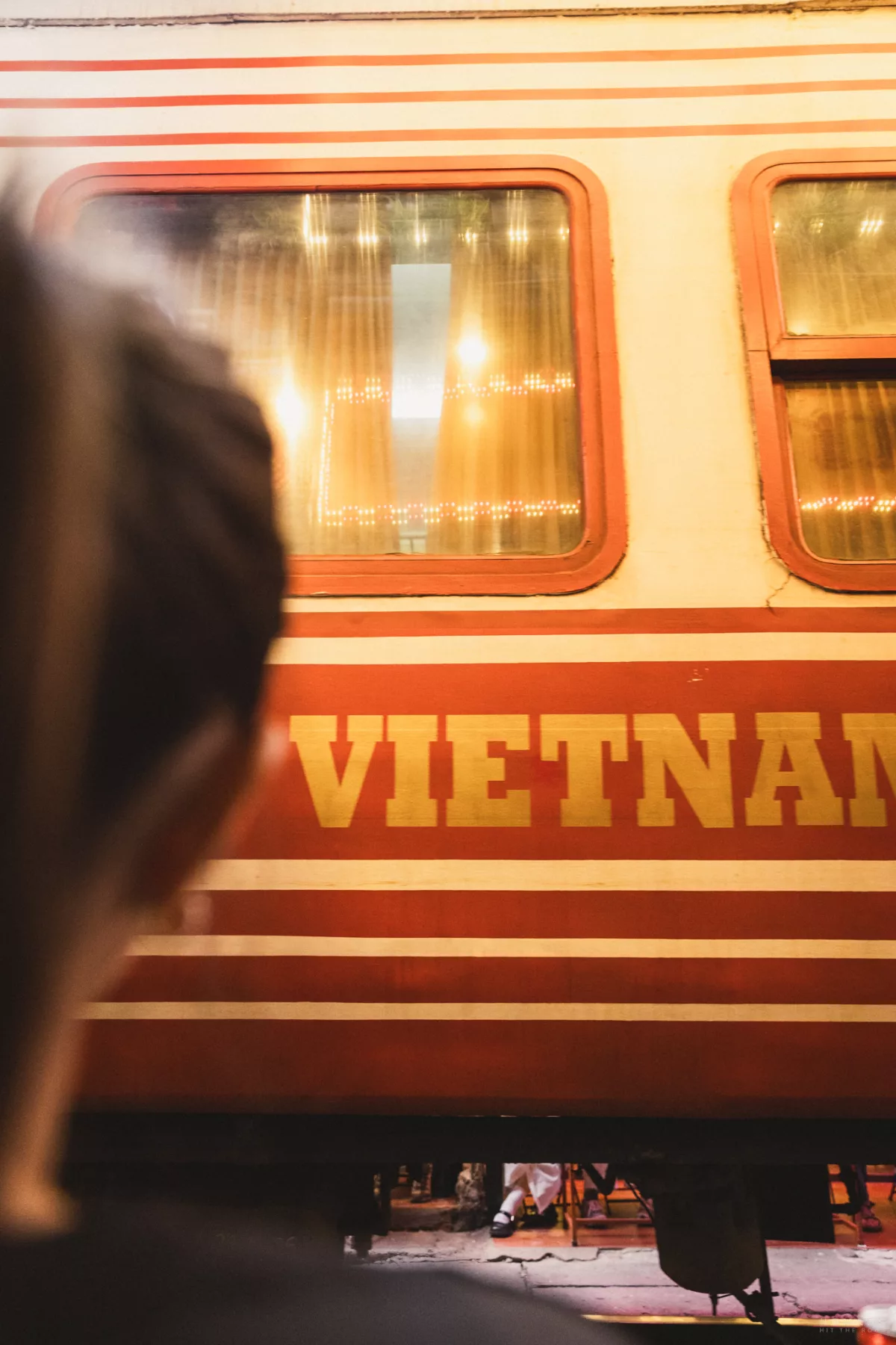 Zug mit der Aufschrift Vietnam fährt nah an einer Person vorbei