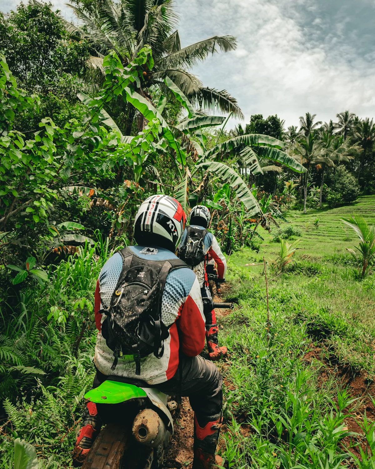 Truppe steht mit Dirt Bikes an Reisfeldern auf Bali
