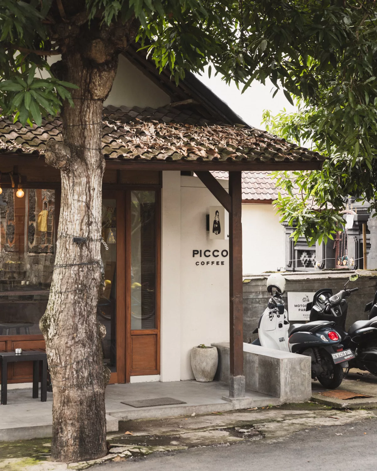 Eingang vom Picco Café mit Parkplatz auf dem Roller stehen nebenan