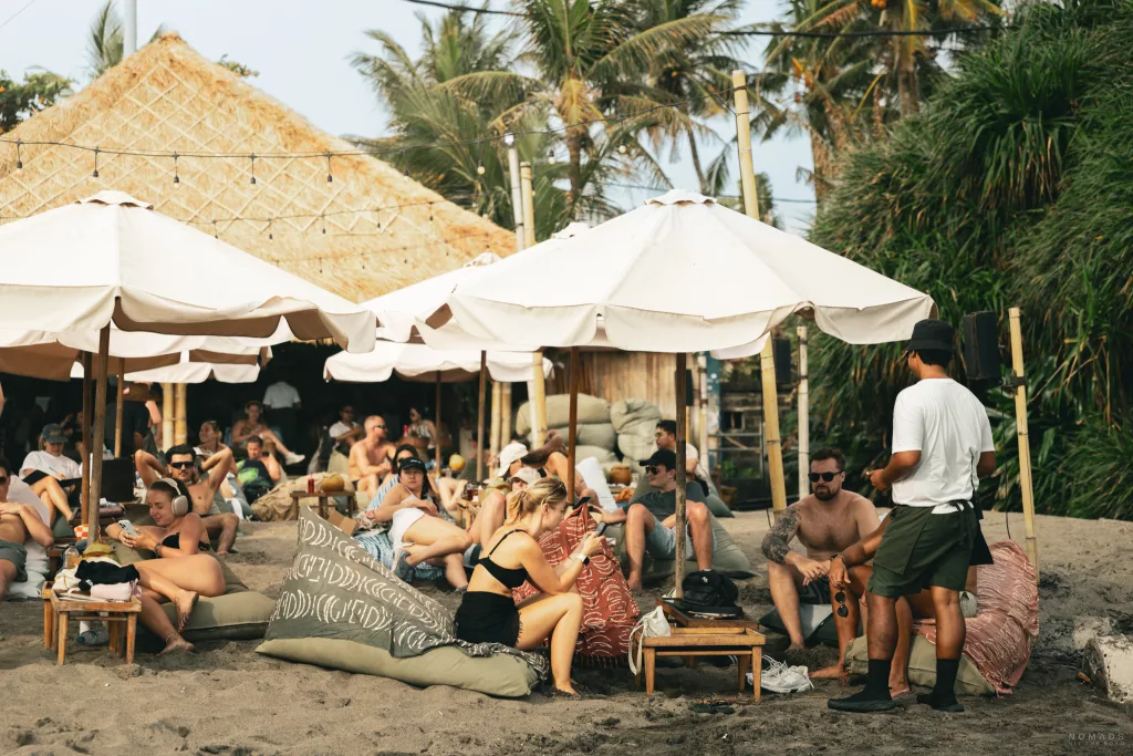 Menschen sitzen auf Sitzsäcken am Times Beach Warung in Canggu auf Bali