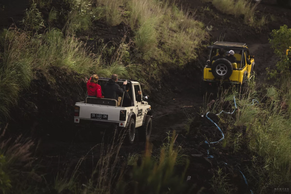 Jeep Wagen mit Menschen drin auf dem Weg bergab