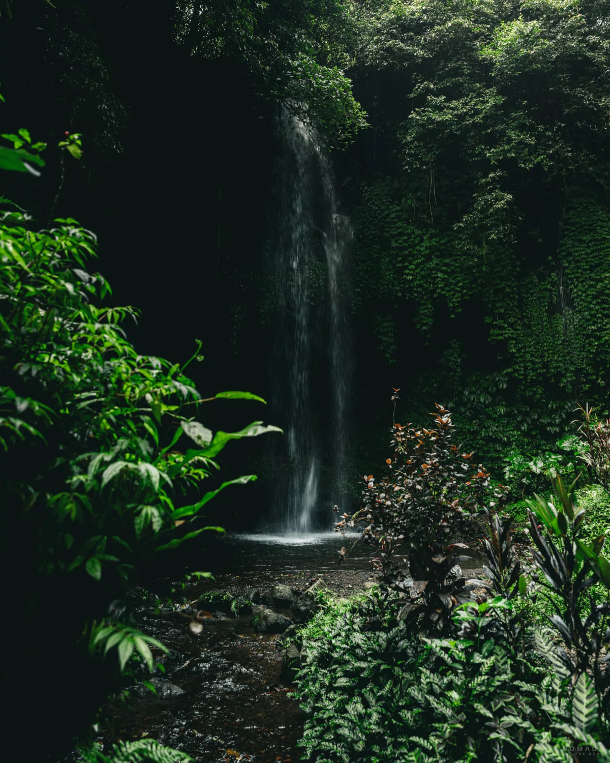 Ein Wasserfall am Banyu Wana Amertha umgeben von grüner Vegetation