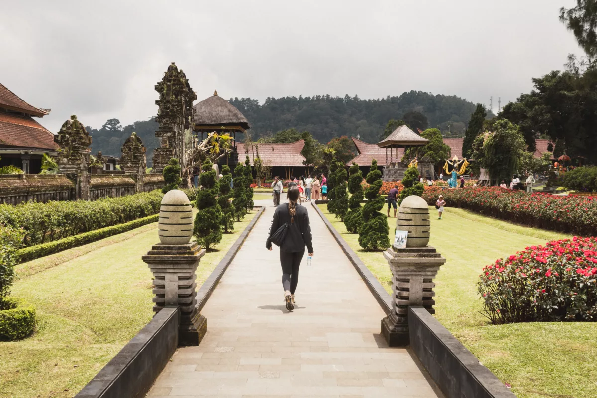 Frau läuft auf dem Gelände rund um den Pura Ulun Danu Bratan