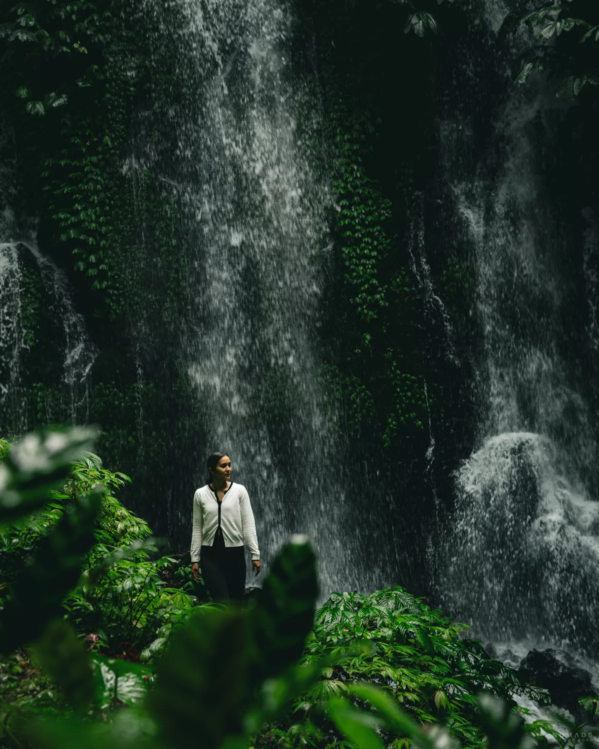 Frau steht vor einem Wasserfall