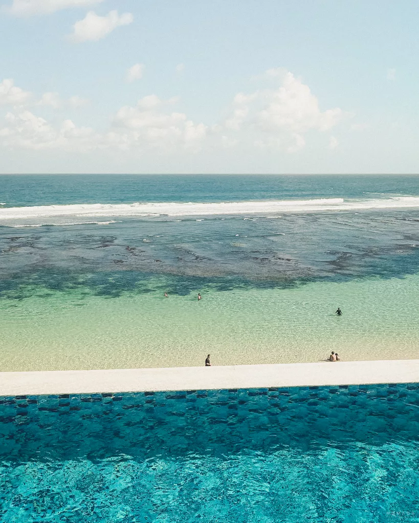 Blick auf das Meer von einem Pool in einem Beach Club