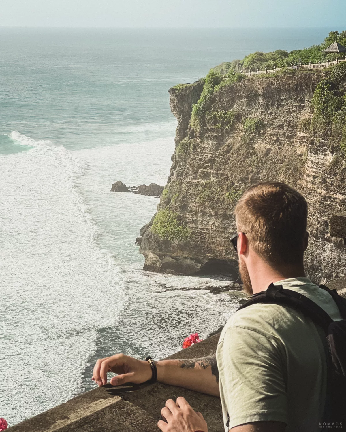 Mann steht an einer Klippe vor dem Meer in Uluwatu