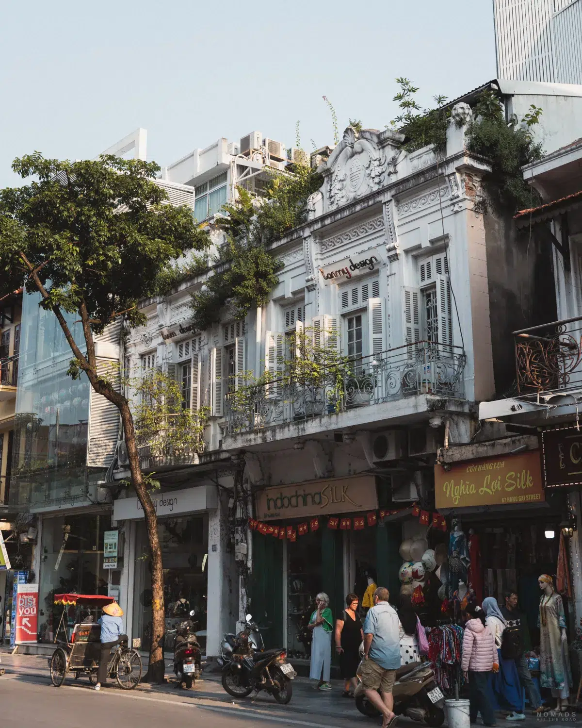 Gebäude und Straße auf denen Menschen laufen im Old Quarter von Hanoi