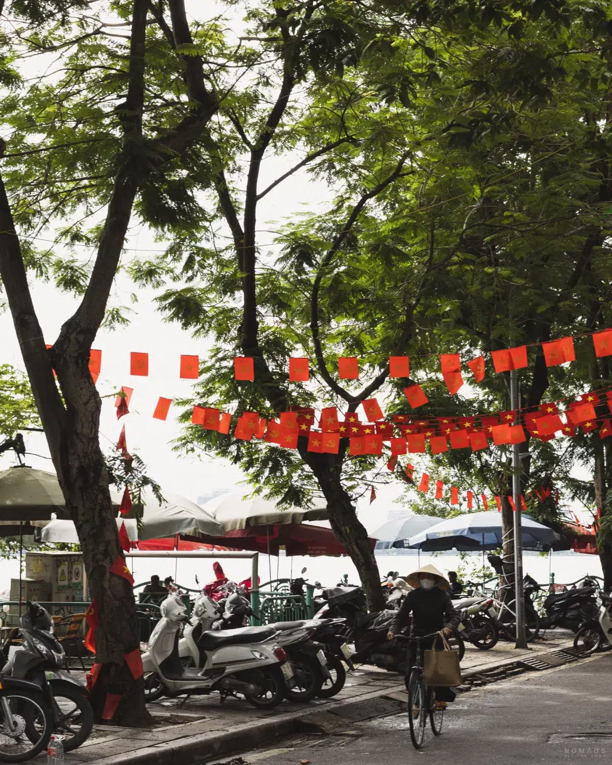 Fahhradfahrerin fährt an parkenden Mopeds auf Bürgersteigen vorbei