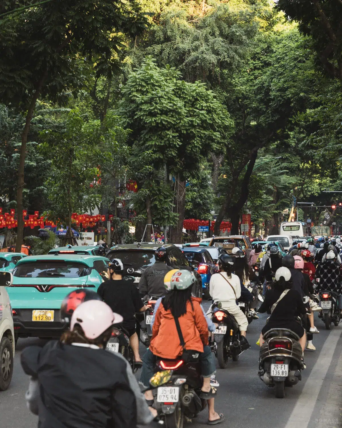 Mopeds und Autos auf einer vollen Straße in Hanoi