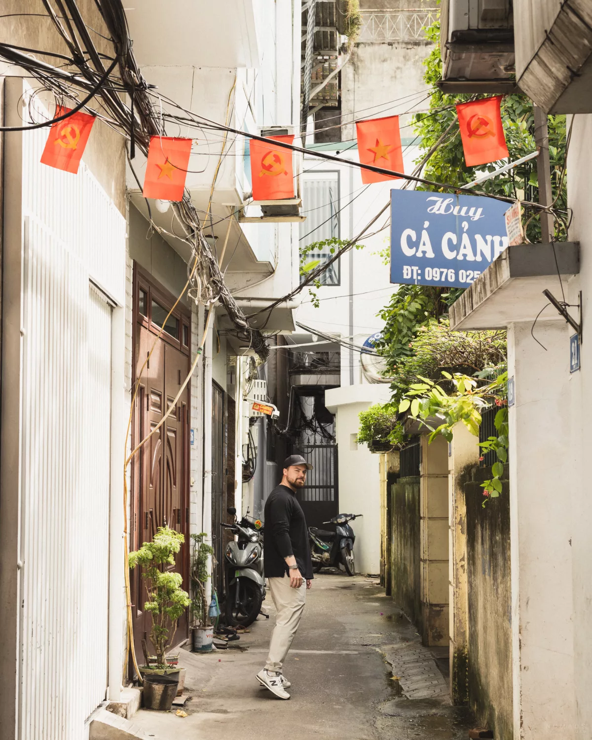 Mann geht durch eine schmale Gasse in einem Wohnviertel in Tay Ho