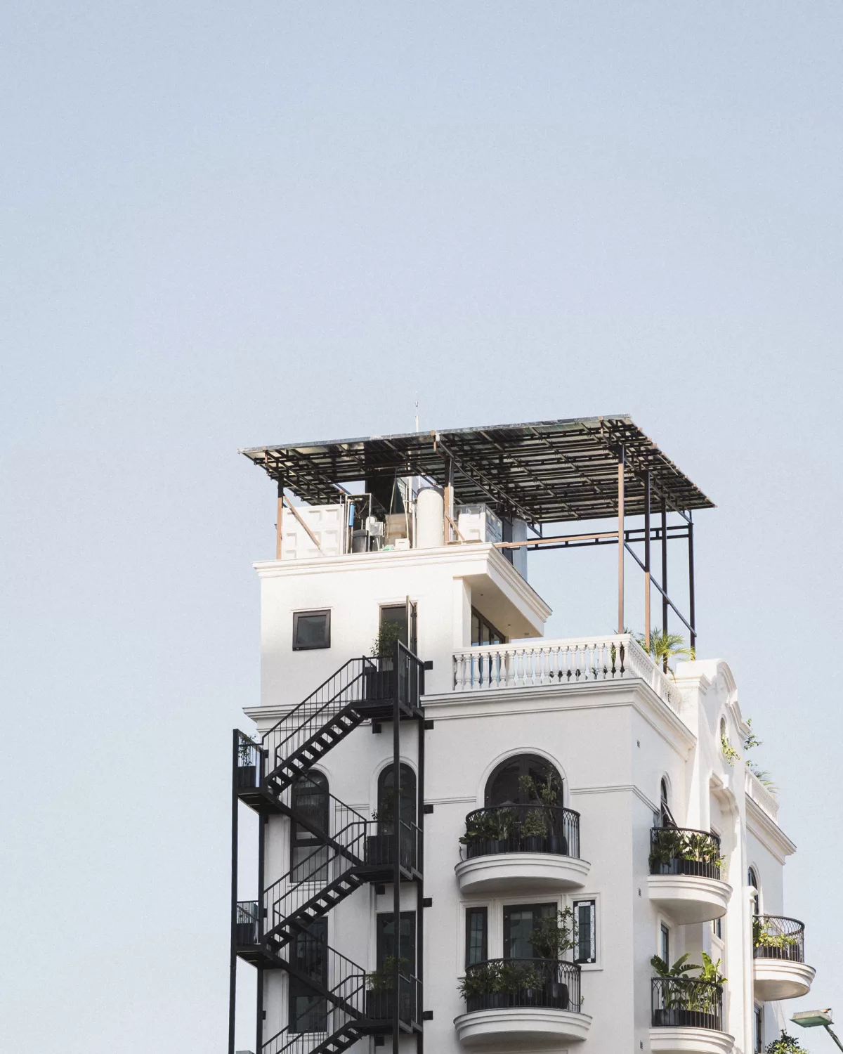 Blick auf ein schmales Gebäude mit Außentreppe und Balkonen