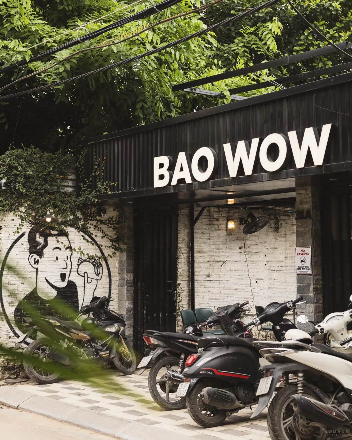 Eingang des Restaurants Bao Wow, vor dem einige Mopeds stehen