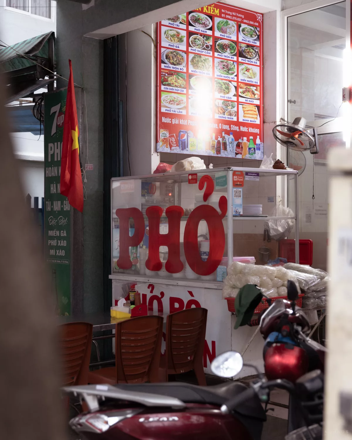 Pho Restaurant in Da Nang mit Menu an der Wand und Stühlen vor dem Laden