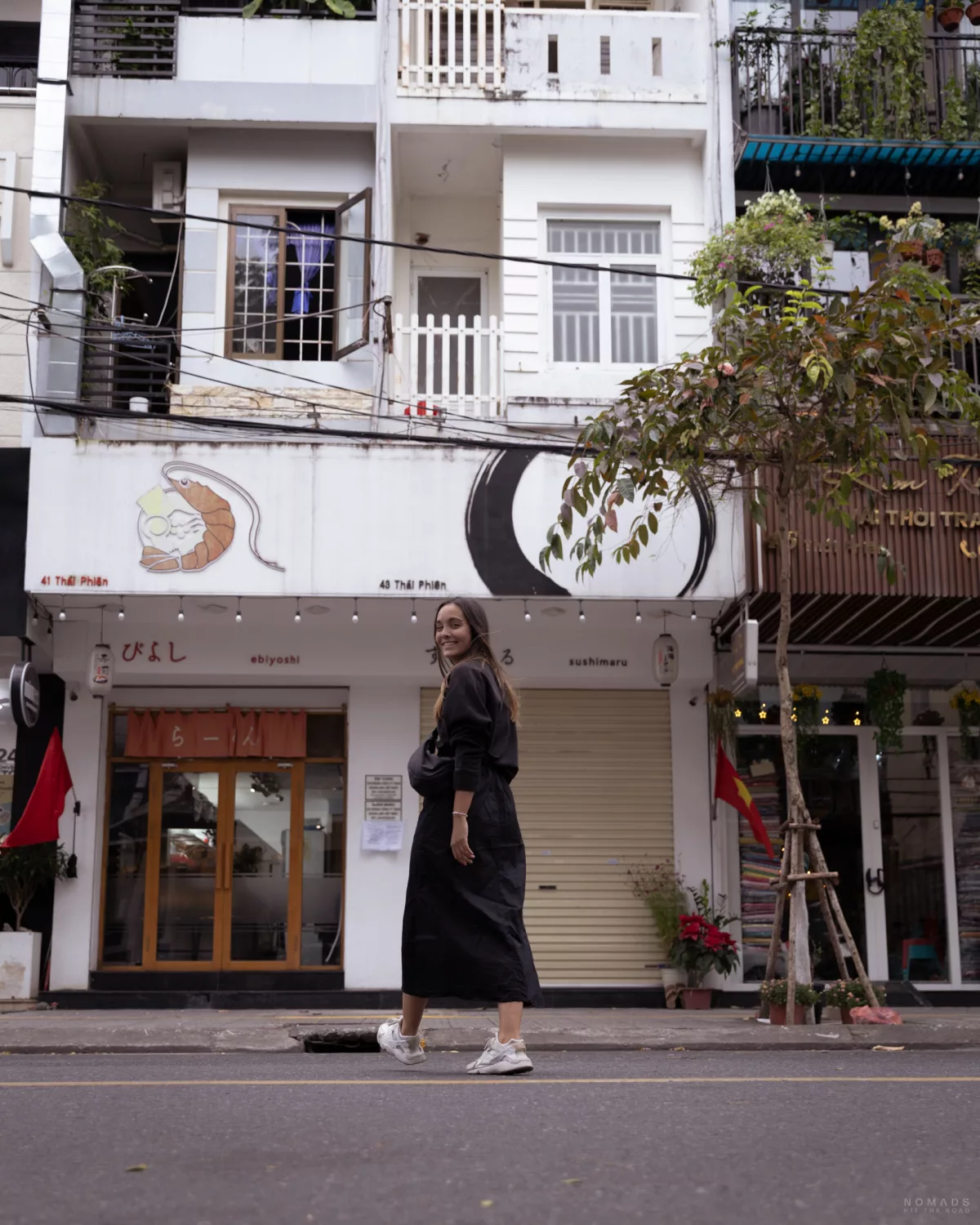 Frau läuft über eine Straße auf das Restaurant Ebiyoshi in Da Nang zu