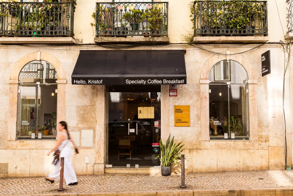 Café Hello, Kristof in Lissabon, auf dem Gehweg davor läuft eine Frau