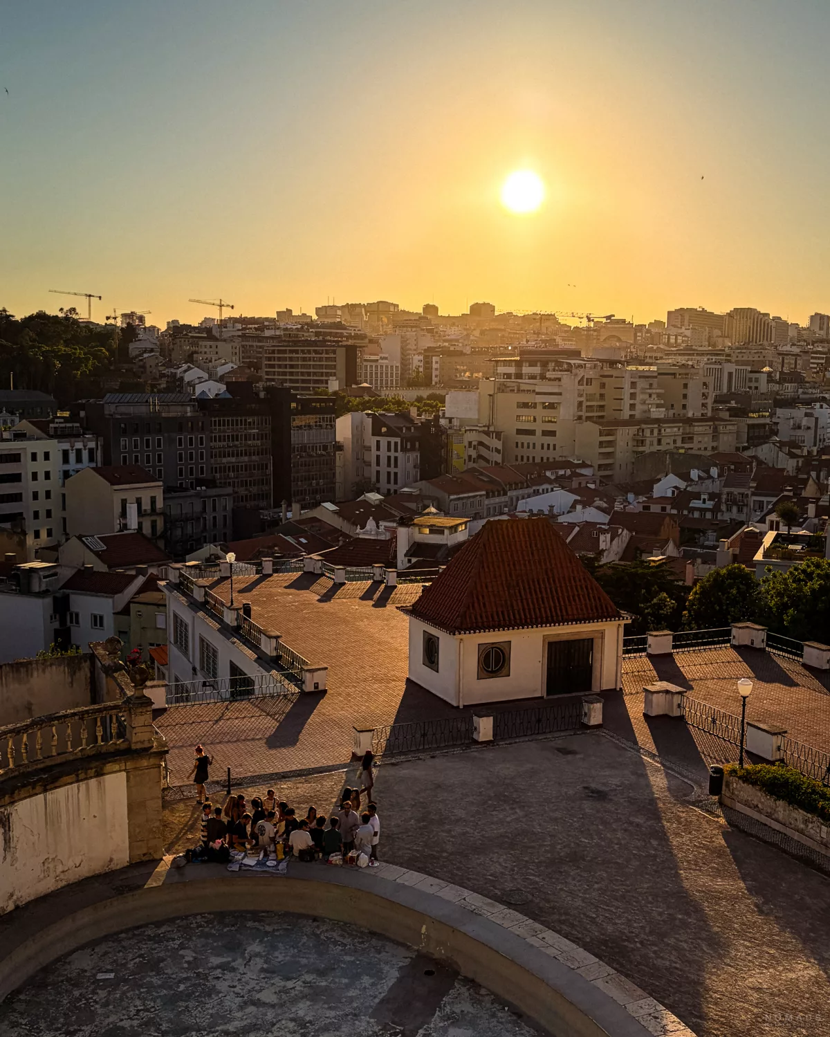 Sonnenuntergang über Lissabon mit Blick auf die Skyline und Menschen versammelt auf einem Platz