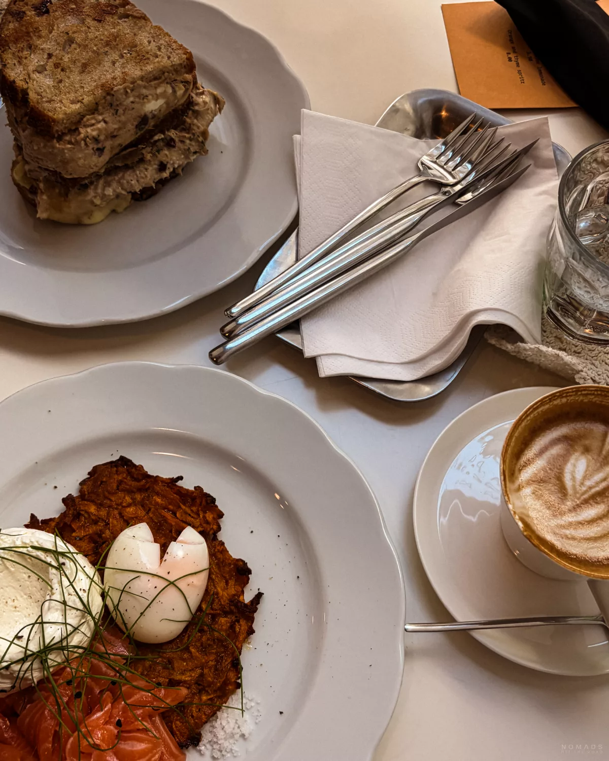 Brot und Lachs auf Tellern, Kaffee und Besteck auf einem Tisch
