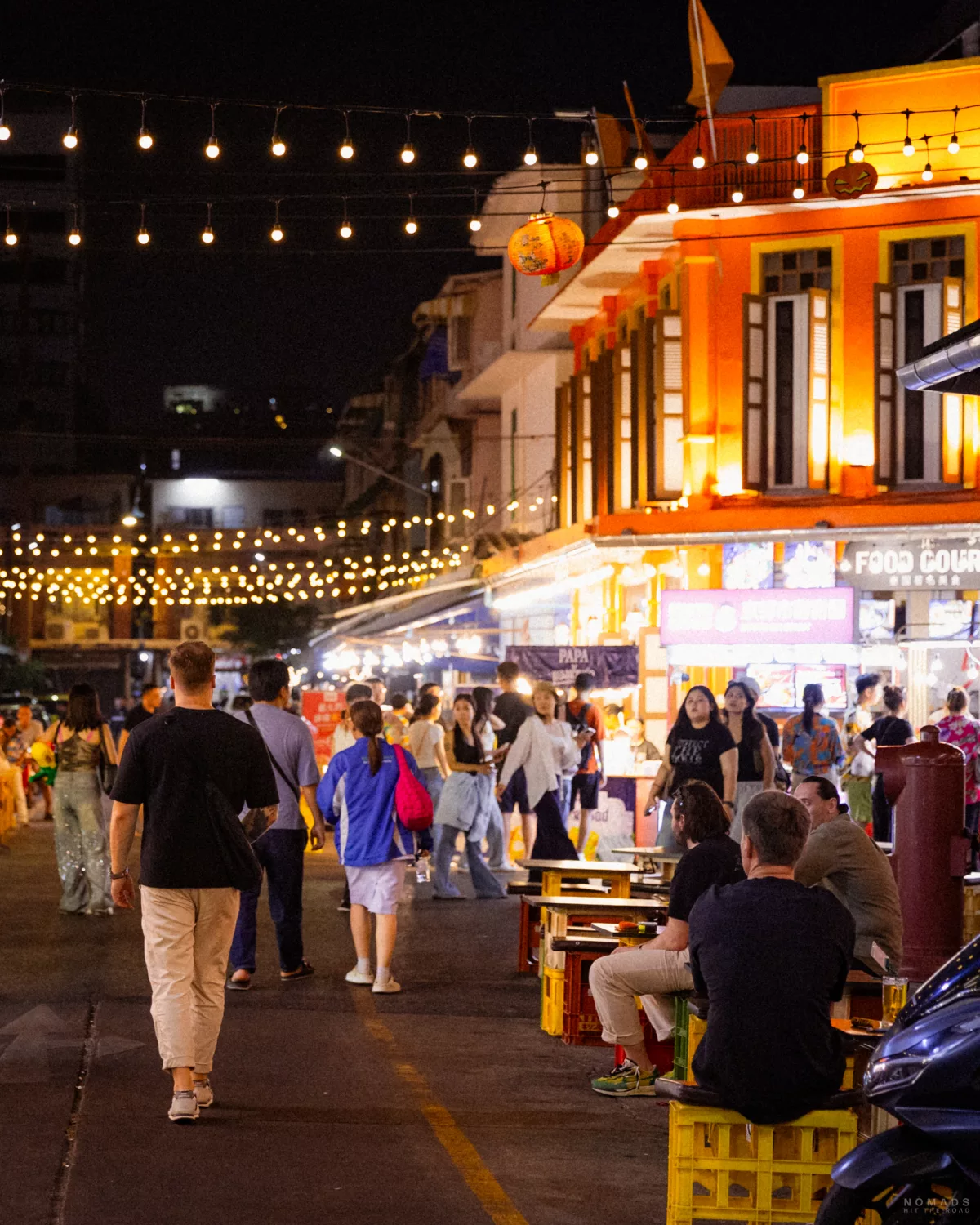 Menschen laufen und sitzen auf dem Nightmarket auf der Banthat Thong Road