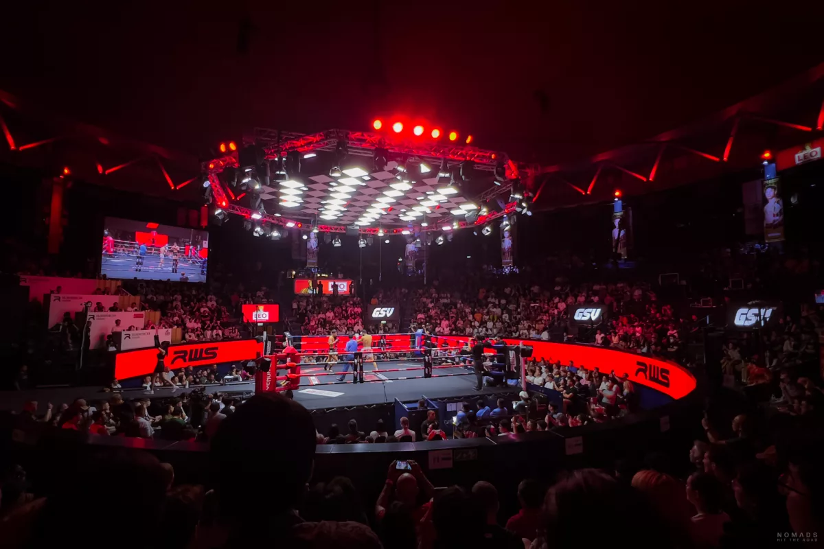 Muay Thai im Rajadamnern Stadion mit Blick auf den Ring und den Sitzplätzen, die im roten Licht beleuchtet werden