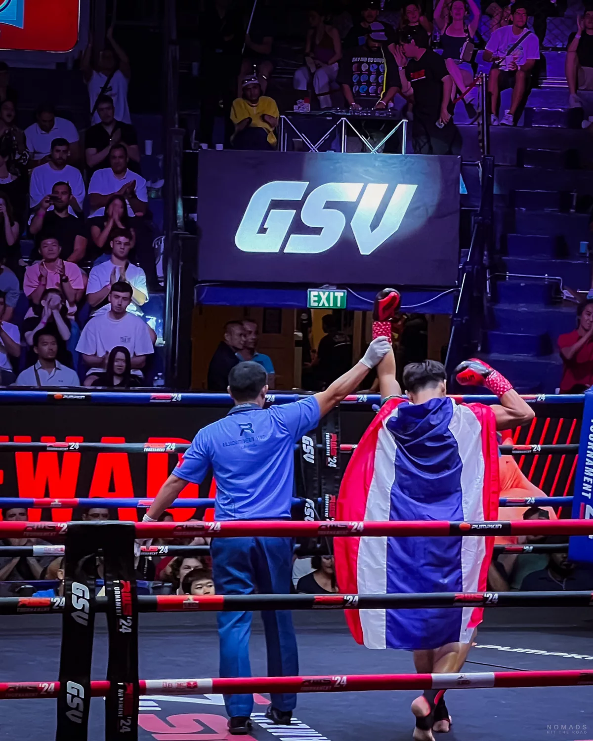 Muay Thai Kämpfer mit umgebundener Thailand Flagge wird zum Sieger erklärt