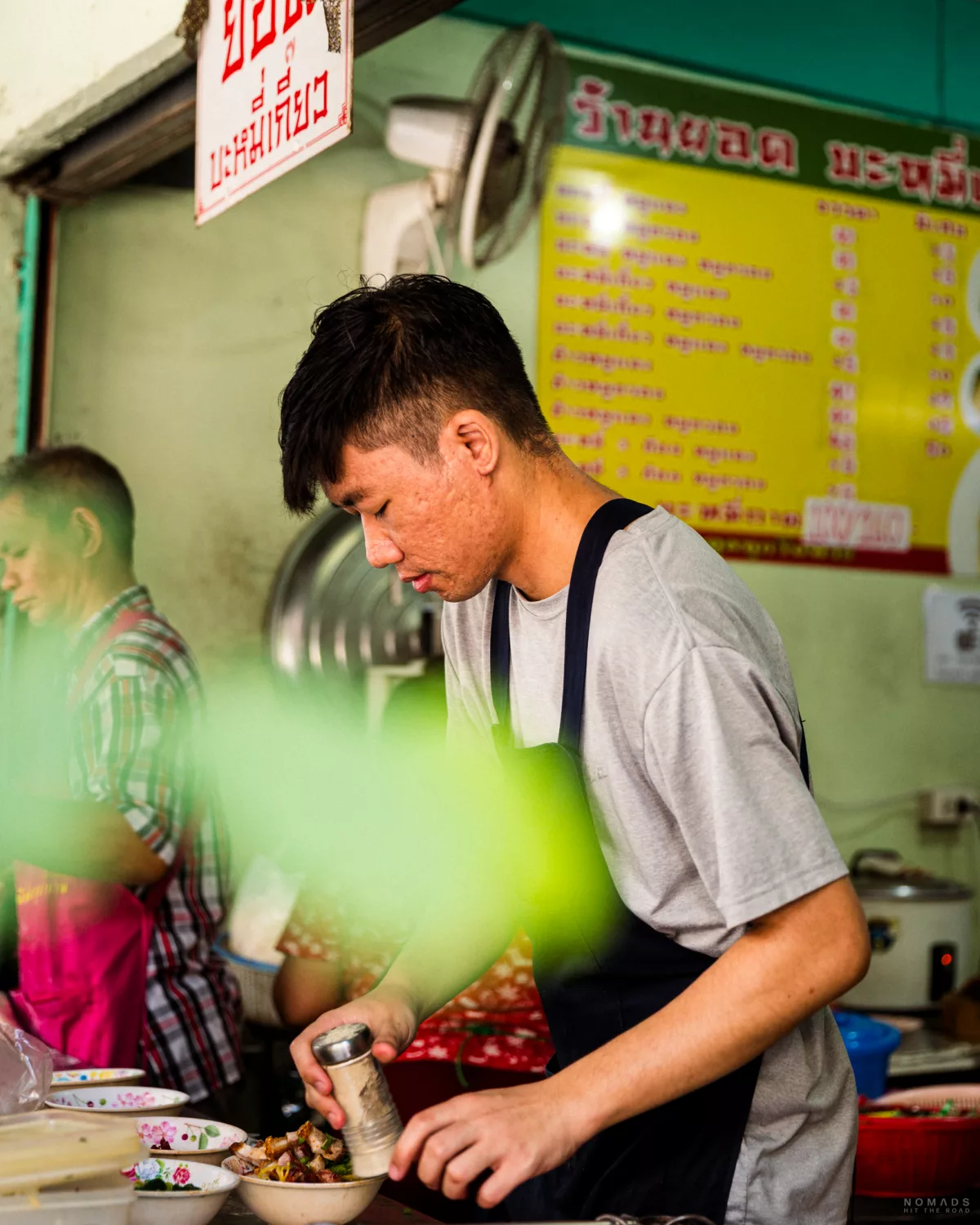 Mann am Streetfood Stand in Bangko bereitet Essen zu