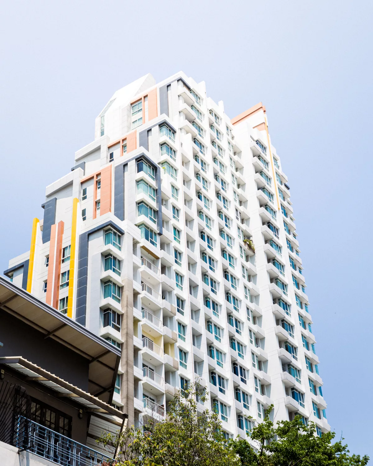 Hochhaus mit weißer Fassade und bunten Akzenten in Bangkok