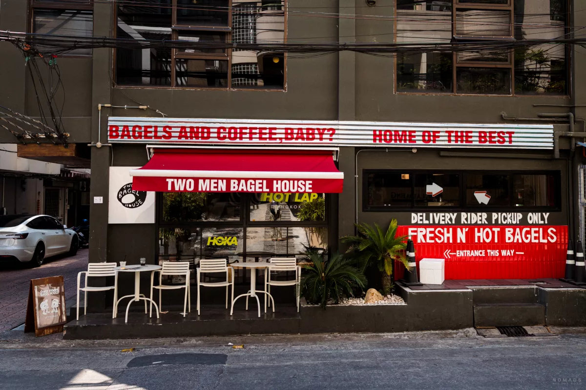 Frontansicht des Bagel Shops Two Men Bagel in Bangkok mit rot-weißer Deko und Schrift