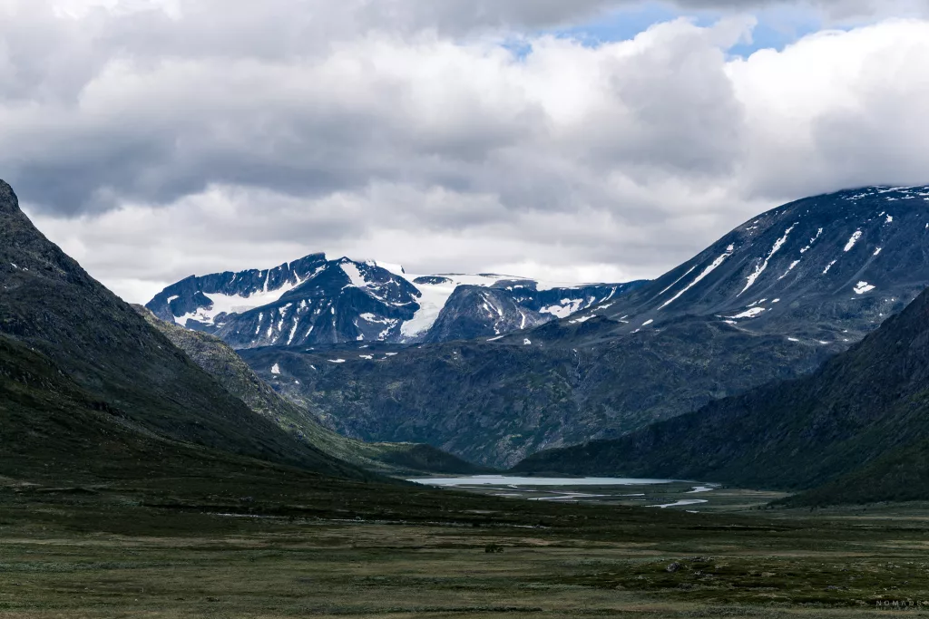 Blick auf schneebehangene Berge, dafür ein See im Jotunheimen Nationalpark in Norwegen