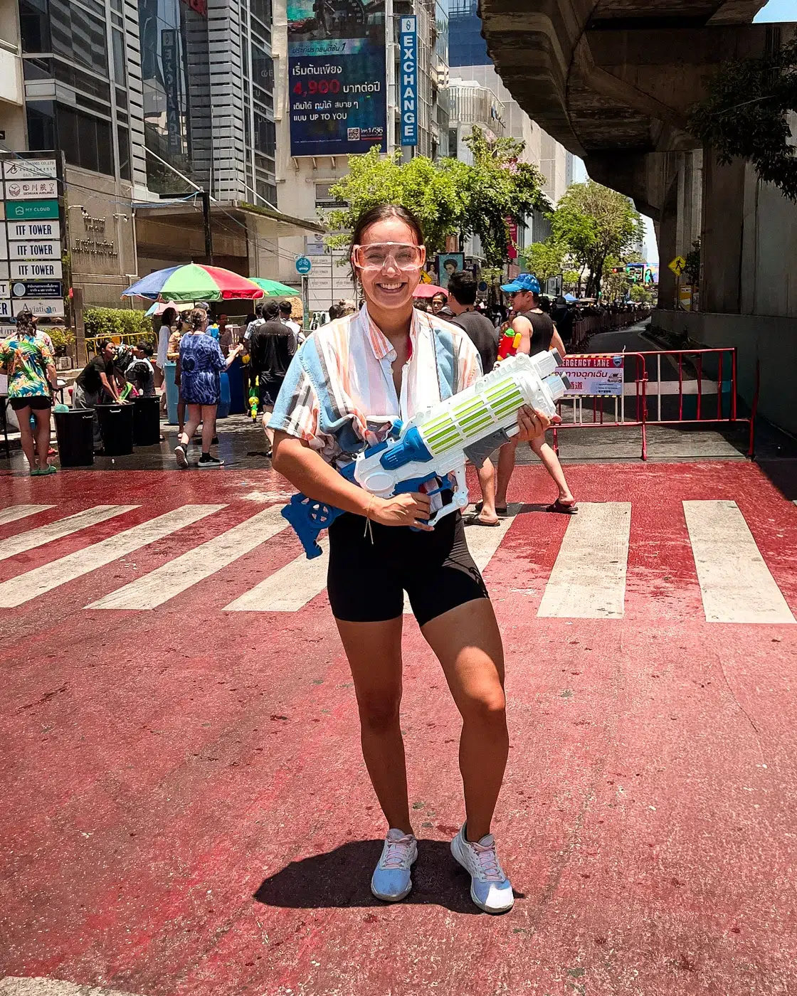 Frau mit Wasserpistole auf den Straßen Bangkoks beim Songkran Festival